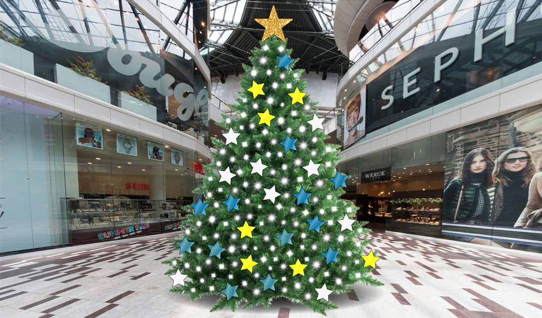 Christmas tree in shopping mall decorated with white lights and a variety of colourful stars (white, yellow, blue, teal).